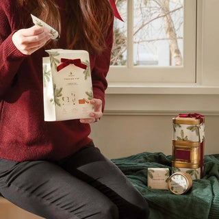 Woman opening Thymes Frasier Fir Holiday Gift Set | Duman Home